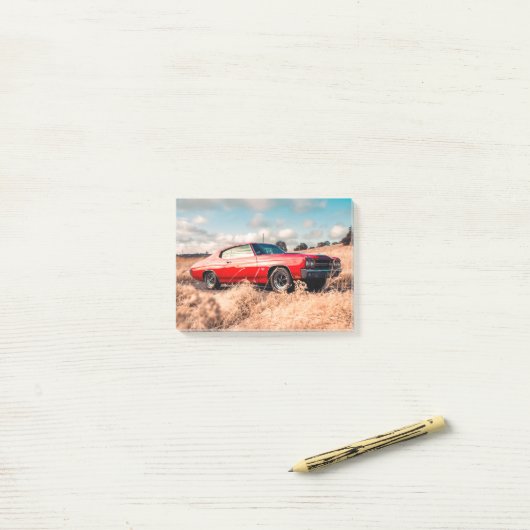 Rode spierwagen in gras. post-it® notes (Op bureau)