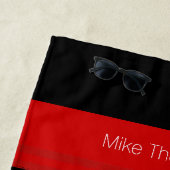 Rode strepen met naam op zwart strandlaken (In situ)