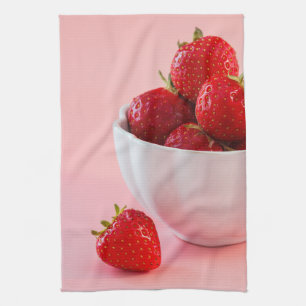 Rode verse aardbeien in een witte kom op roze theedoek