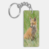 Rode voskit in gras bij hol sleutelhanger (Voorkant Links)