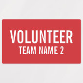 Rode vrijwilligersbadge met de naam van het Team v Labels (Design 2)