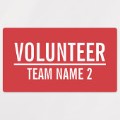 Rode vrijwilligersbadge met de naam van het Team v Labels (Design 2)