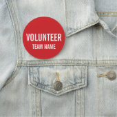 Rode vrijwilligersbadge met de naam van het Team v Naamplaatje (In situ)