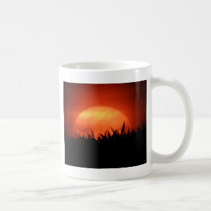 Rode zonsondergang achter zwart gras koffiemok