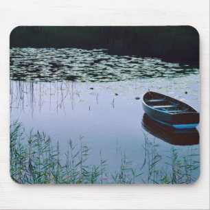 Roeiboot op klein meer omringd door water muismat