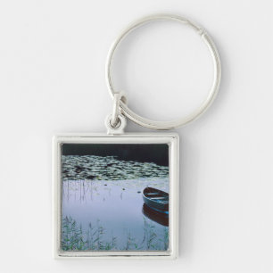 Roeiboot op klein meer omringd door water sleutelhanger