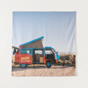 Rood en blauw voertuig naast man wandkleed