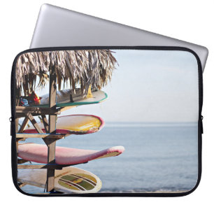 Rood en wit surfbord in bruin houten rek laptop sleeve