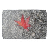Rood herfst blad in regen op grijze, getextureerde badmat (Voorkant)