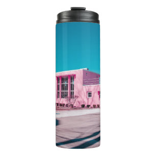 Roze betonbouw onder duidelijke blauwe hemel thermosbeker