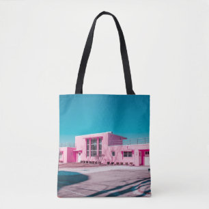 Roze betonbouw onder duidelijke blauwe hemel tote bag