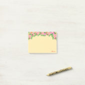 Roze bloemen en kalligrafie op lichtgeel post-it® notes (Op bureau)