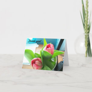 Roze desktoptulpen op een gevouwen bedankt kaart