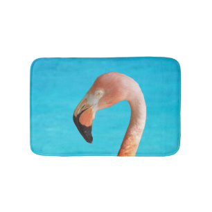 Roze flamingo gezicht tegen blauw water op badmat