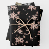 Roze goudgele goudzilversneeuwvlokken zwart inpakpapier vel (In situ)