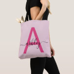 Roze moderne script meisjesnaam monogram tote bag<br><div class="desc">Verhef je dagelijkse stijl met deze op maat gemaakte monogram-tas. Met een opvallende roze letter "A" en elegante script die je naam personaliseert, combineert deze tas moderne minimalisme met een meisjesachtige touch. Het ruim bemeten, duurzame ontwerp maakt het de perfecte accessoire voor elke gelegenheid - of je nu boodschappen doet,...</div>