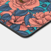 Roze rozen met blauwe bladeren op blauw bureaumat (Hoek)