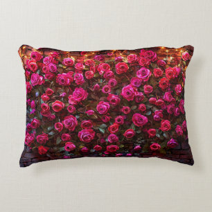 Roze rozen op bakstenen muur met decoratieve licht accent kussen