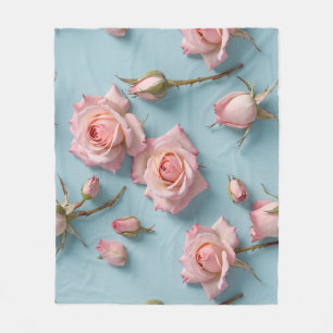 Roze rozen verspreid over een lichtblauwe achtergr fleece deken
