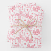 Roze strikken en donkerroze stippen inpakpapier vel (In situ)