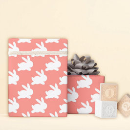 Roze zalmkonijn loopt rond cadeaupapier