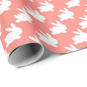 Roze zalmkonijn loopt rond cadeaupapier (Rol Hoek)