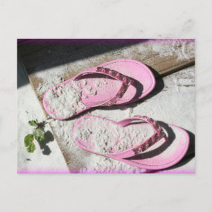 Roze zandige flip flop-sandalen op het strand van  briefkaart