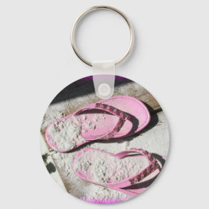 Roze zandige flip flop-sandalen op het strand van sleutelhanger