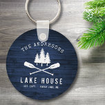 Rustic Lake House Oars Trees Blue Wood Print Round Sleutelhanger<br><div class="desc">Een prachtige, rustige ronde sleutelhanger, met uw familienaam en "Lake House" of andere gewenste tekst, samen met de vastgestelde datum en locatie. Dit unieke ontwerp is voorzien van een wit silhouet van gekruiste bootzeuren en dennenbomen op een drukplaat van houtplanken in rijke blauwe kleuren. Ideaal voor bedrijven met de naam...</div>