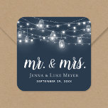 Rustic String Lights Mr. en Mrs Wedding Monogram Vierkante Sticker<br><div class="desc">Op maat gedrukte stickers gepersonaliseerd met uw Mr en Mrs monogram en trouwdatum, ideaal voor huwelijksgunslabels, welkomsttassen of envelopzegels met uw uitnodigingen. Het ontwerp is voorzien van gloeiende snaarlampen en metselaarpotten op een marineblauwe achtergrond. Gebruik de ontwerpgereedschappen om een achtergrondkleur te kiezen, de tekstlettertypen en -kleuren te wijzigen of uw...</div>