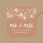 Rustic String Lights Mr. en Mrs Wedding Monogram Vierkante Sticker<br><div class="desc">Aangepaste bedrukte stickers op maat gemaakt met uw Mr. en Mrs. monogram en trouwdatum, perfect voor trouwbonborden, welkomstzakken of envelopzegels met uw uitnodigingen. Het ontwerp is voorzien van gloeilampen en moeraspotten op een teracotta roest background. Gebruik de ontwerphulpmiddelen om het even welke achtergrondkleur te kiezen, de tekstdoopvonten en de kleuren...</div>