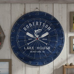 Rustieke familie Lake House Navy Blue Wood Dartbord<br><div class="desc">Voeg een persoonlijk tintje toe aan uw familiehuis aan het meer of huisje aan het bergmeer met dit rustieke dartbord, met gekruiste riemen en een springende vis op een rustieke marineblauwe houten achtergrond, met familienaam, locatie van het meerhuis en gevestigde datum in gemakkelijk te gebruiken tekst-sjablonen.</div>