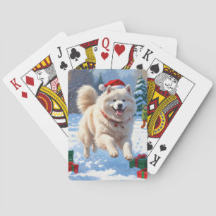Samojed loopt in de sneeuw met kerstmuts pokerkaarten
