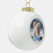 Samoyed loopt in de sneeuw met kerstmuts keramische bal ornament (Links)