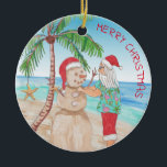 Sandy Snowman Snowbird Kerstmis Keramisch Ornament<br><div class="desc">Waterverf Santa Claus bouwt een zandsneeuwman op het strand onder een palmboom met oceaan op de achtergrond. Verdomd ornament voor iemand die aan de kust leeft of je sneeuwvogelouders.</div>