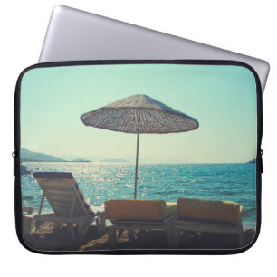 Sandy strand op een zonnige namiddag met parasols laptop sleeve