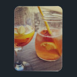 Sangria and Sunshine Magneet<br><div class="desc">This image shows a refreshing glass and pitcher of citrus sangria, perfect for a warm day. The fresh slices of lemon and orange add bright colour and hint of natural sweetness. One glass sits ready to enjoy while sangria is being poured from a small glass pitcher beside it, perfect for...</div>