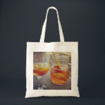 Sangria and Sunshine Tote Bag<br><div class="desc">This image shows a refreshing glass and pitcher of citrus sangria, perfect for a warm day. The fresh slices of lemon and orange add bright colour and hint of natural sweetness. One glass sits ready to enjoy while sangria is being poured from a small glass pitcher beside it, perfect for...</div>
