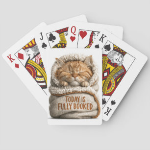 Schattig slapend kaneelkatje in een deken gewikkel pokerkaarten