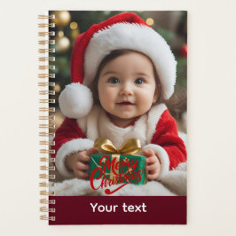 Schattige Baby in Santa Outfit met kerstcadeau Planner