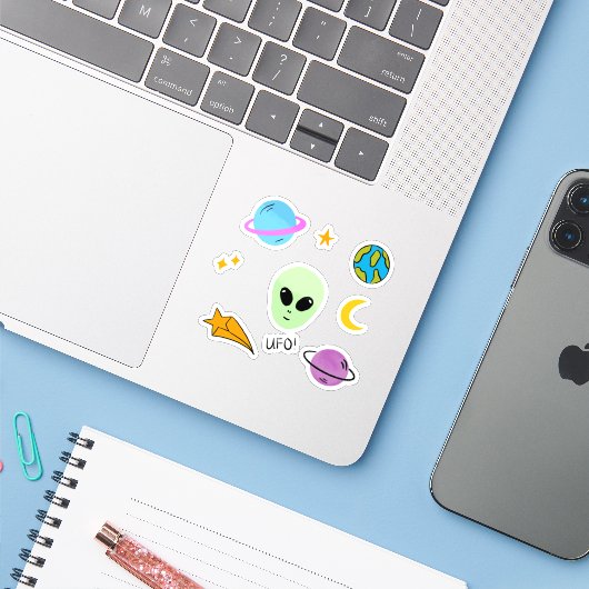 Schattige buitenaards hoofd met planeten, ufo’s en sticker (Laptop met iPhone)