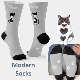 Schattige grappige tuxedo kat & poten op lichtgrij sokken