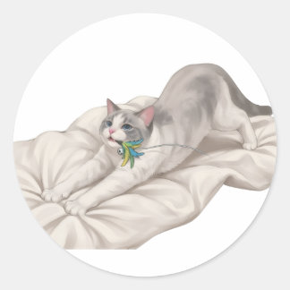 Schattige kat die zich uitrekt en speelt met veren ronde sticker