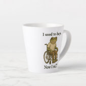 Schattige kikkertje in een rolstoel die positief i latte mok (Rechterhoek)