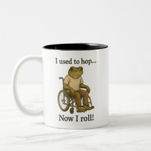 Schattige kikkertje in een rolstoel die positief i tweekleurige koffiemok
