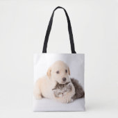 schattige kleine kattenslaapt in de handen van de  tote bag (Voorkant)