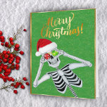 Schattige lachend skelet Ornamenten Santa Hat Groe Feestdagen Kaart<br><div class="desc">Dit wenskaart heeft een schattig skelet met twee glanzende kerstversieringen met sneeuwvlokken tot aan zijn ogen met een rode kerstmuts op een groene achtergrond met faux gouden sprankels en een gouden lijst. Pas het binnenste vers plus jouw naam aan met de sjablonen.</div>