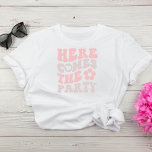 Schattige Retro Script Bachelorette Party T-shirt<br><div class="desc">Schattige vrijgezellenfeest T-shirt met "Here Comes The Party" in een roze en taupe retro lettertype en een illustratie van een 70's style flower. Een coördinerende "Here Comes The Bride" jas is beschikbaar voor de bruid.</div>