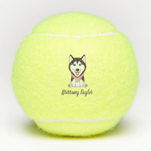 Schattige zwart-witte husky hond tennisballen