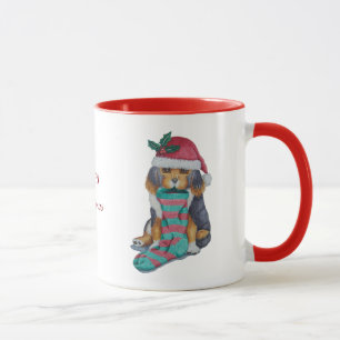 schattige zwarte en bruine puppy met kerstmis mok